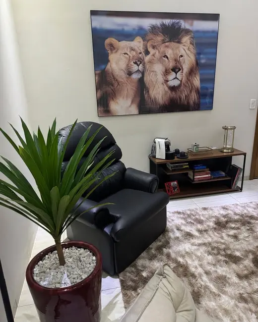 Sala de atendimento presencial com poltrona de couro e quadro de leões